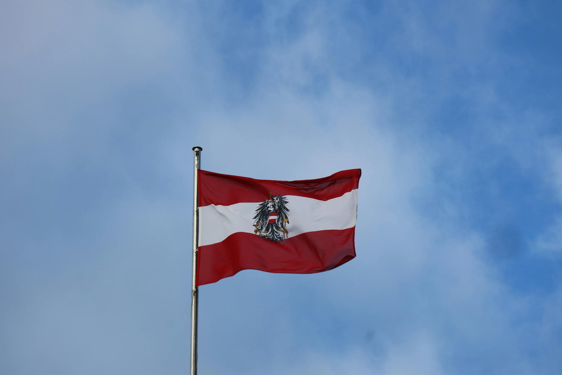 Flaga Austrii z orłem na tle błękitnego nieba w Wiedniu