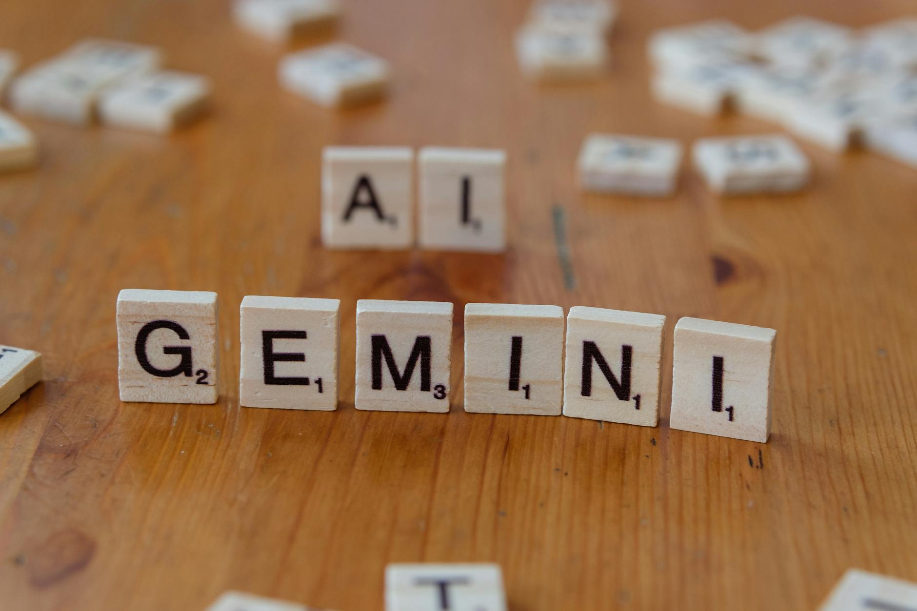 Kafle Scrabble układające się w słowa Gemini i AI na drewnianym blacie
