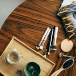 Płaskie ujęcie pędzli do makijażu, magazynu Vogue i kawy na drewnianym stole