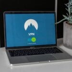 Laptop z ekranem VPN na biurku obok sukulenta, symbol bezpieczeństwa online