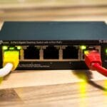 Przełącznik TP-Link z podłączonymi kablami Ethernet w małej firmowej sieci