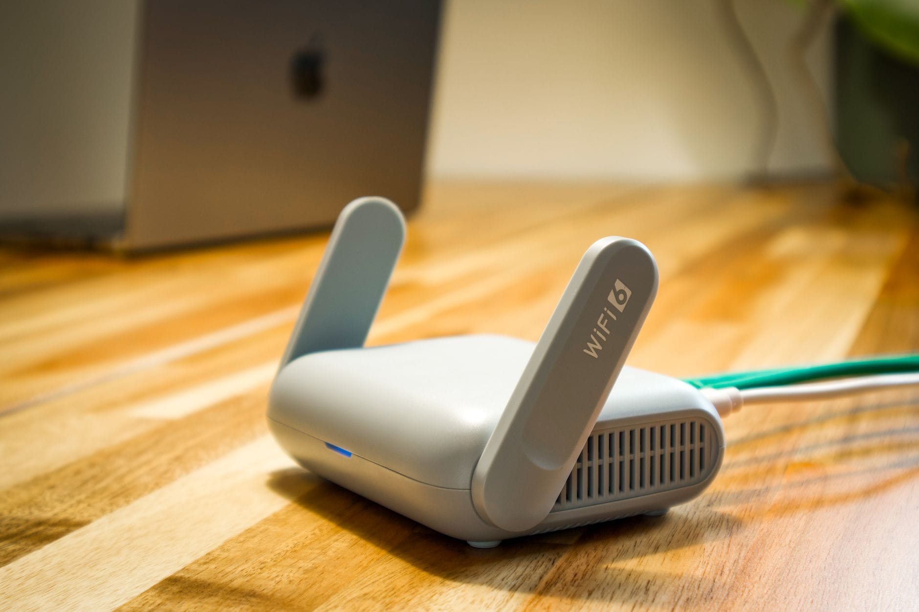 Router WiFi 6 z antenami na drewnianym biurku w nowoczesnym domu